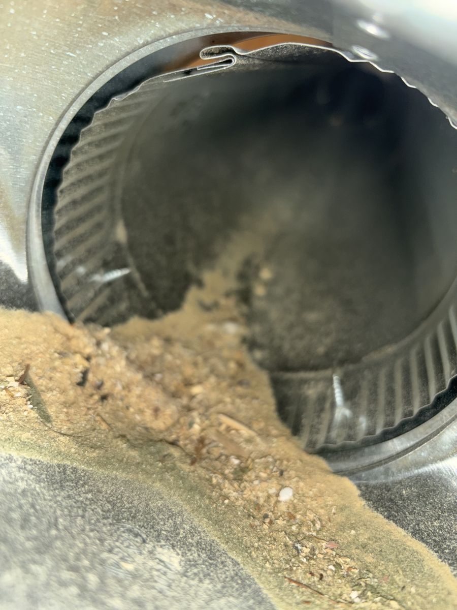Round duct opening with sawdust and wood chips before cleaning