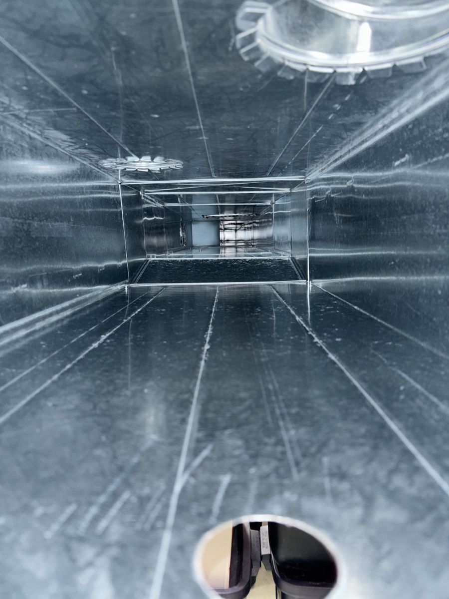 The same trunk duct after cleaning, shiny bare metal