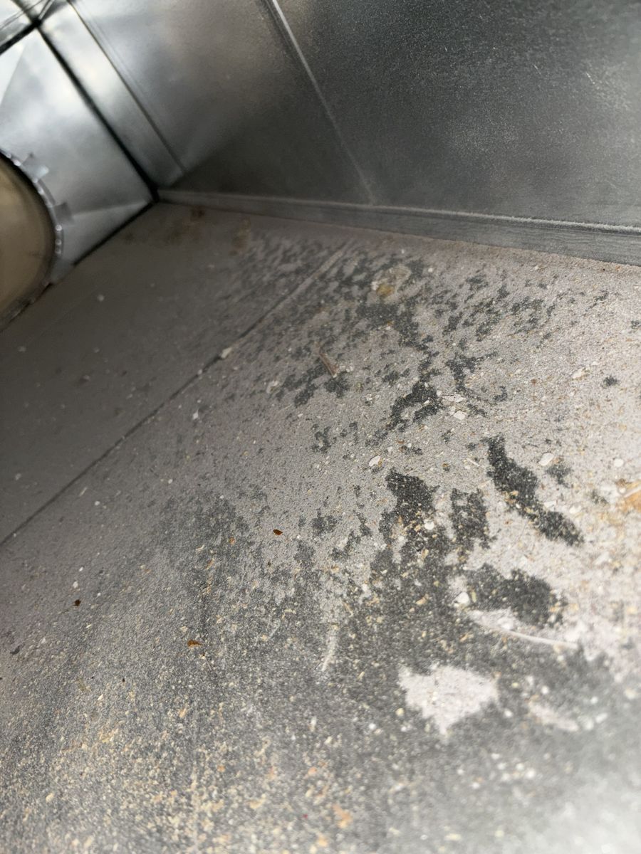Rectangular duct floor covered in grey dust and sawdust before cleaning