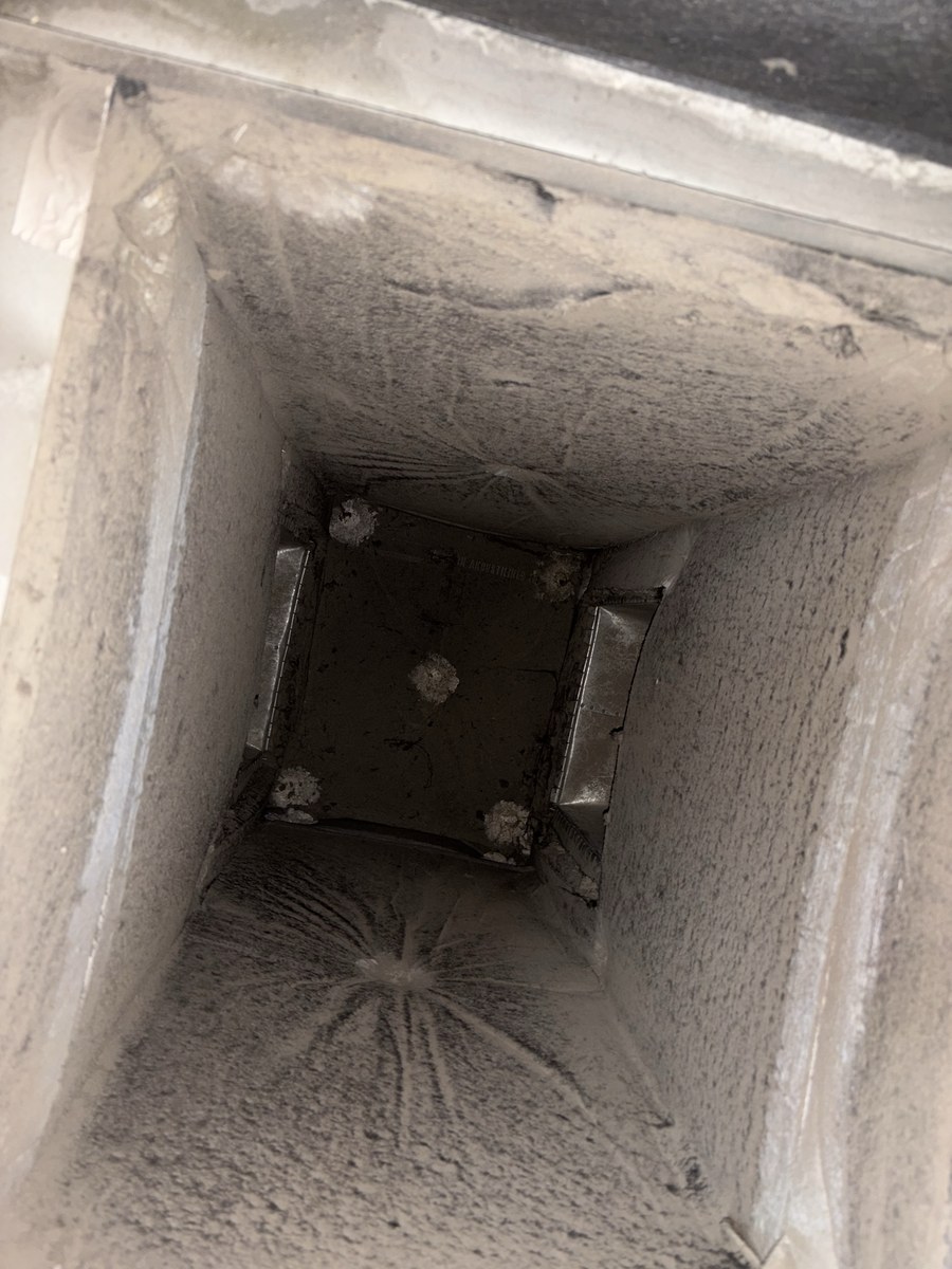 Lined commercial duct before cleaning, coated in dust