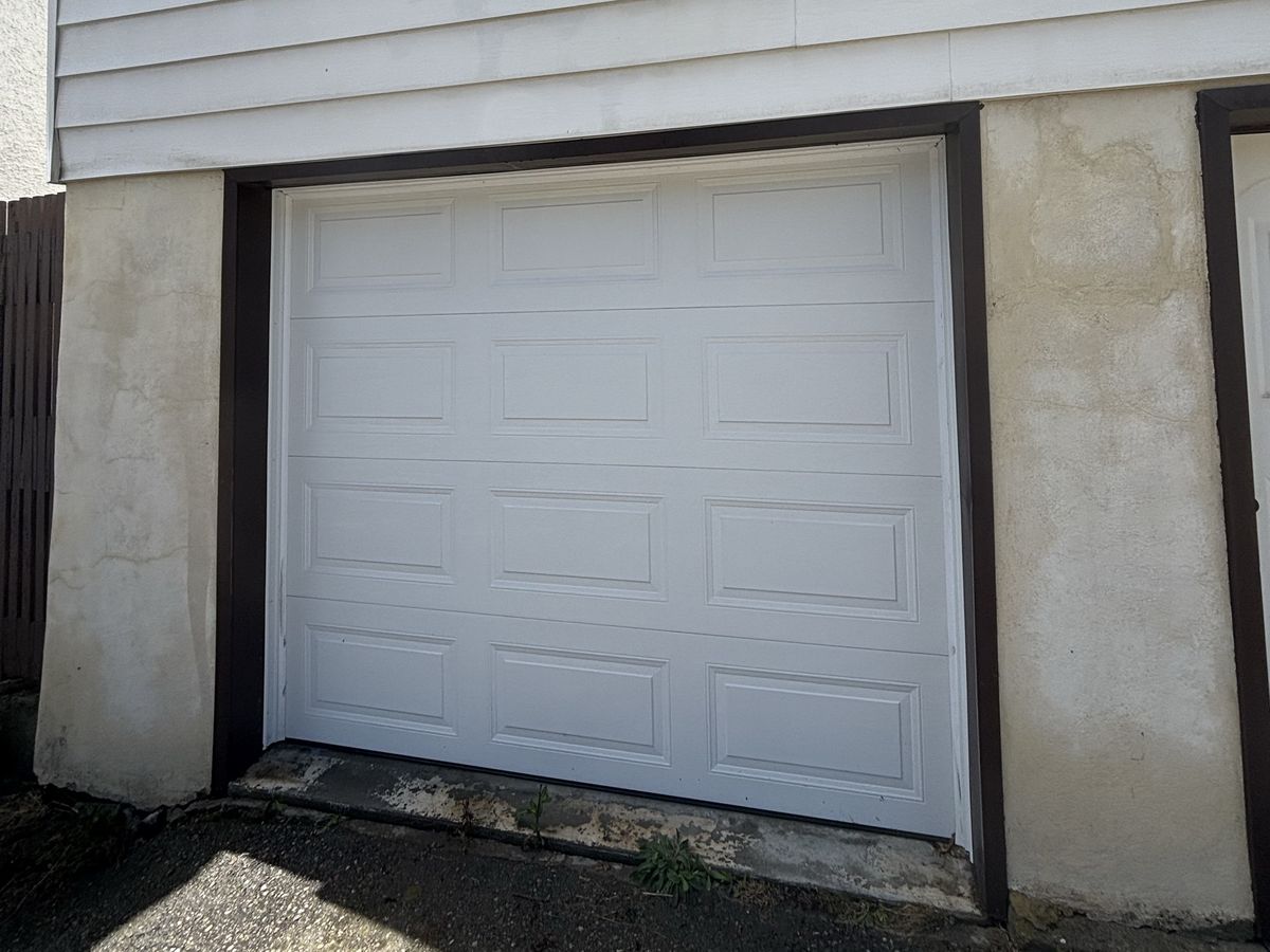 The same garage door after a soft wash, clean white panels